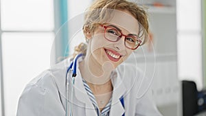 Young woman doctor wearing glasses smiling at the clinic