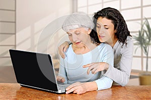 Young woman doctrine teaches daughter of an elderly woman laptop computer