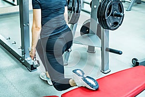 Young woman does leg lunge exercises in gym