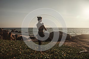 Young woman does yoga for healthy lifestyle on sea beach