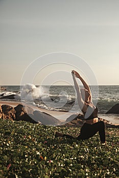 Young woman does yoga for healthy lifestyle on sea beach