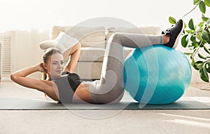 Young woman doing abs crunches with fitball