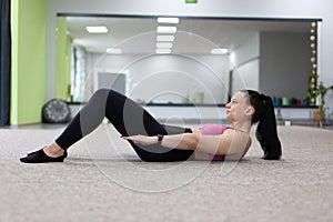 Young woman doing abs exercise on the floor