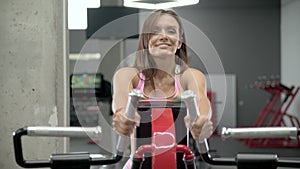 Young woman doing a back exercise in the machine gym