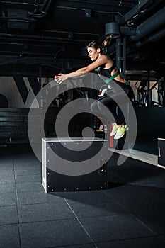 Young woman doing a box jump exercise.