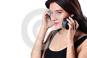 Young woman doing a bWoman listening to music on headphones enjoying a musicicep curl isolated on whit