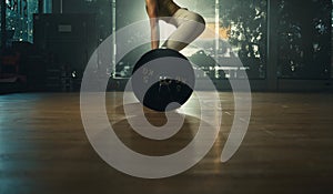 Young woman doing deadlift with heavy bar in gym, strong female athlete with muscular body lifting weights, exercising with