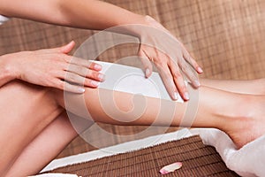 Young woman doing depilation on legs