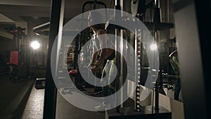 Young woman doing exercise for back on training machine