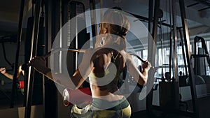 Young woman doing exercise for back on training machine