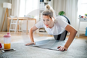 Young woman doing exercise on the floor indoors at home.