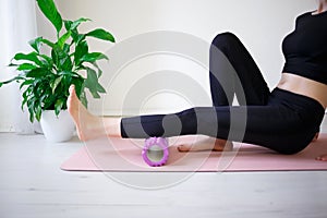 Young woman doing exercises on a massage roller