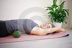 Young woman doing exercises on a massage roller