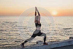 Young woman doing exercises near the sea