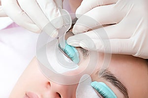 Young woman doing eyelash lamination procedure