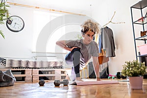 Young woman doing fitness exercise at home