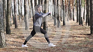 Young woman doing fitness exercises outdoors. Fit girl doing lunges in park.