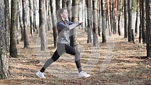 Young woman doing fitness exercises outdoors. Fit girl doing lunges in park.