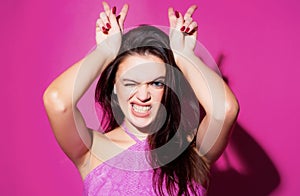 Young woman doing funny gesture with finger over head as bull horns. Crazy funny sexy girl doing funny gesture with