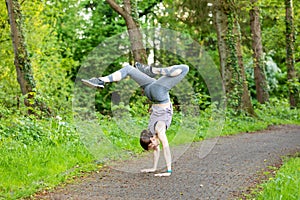 Young woman doing a handstand as a fitness workout