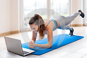 Young woman doing home workout on yoga mat