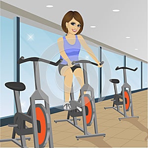 Young woman doing indoor biking exercise at gym