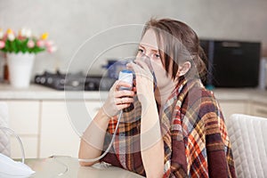 Young woman doing inhalation with a nebulizer at home