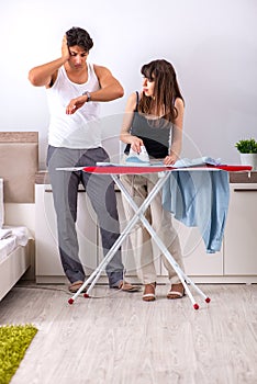 The young woman doing ironing for her husband