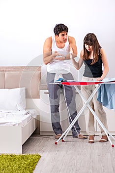 The young woman doing ironing for her husband