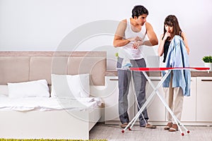 The young woman doing ironing for her husband