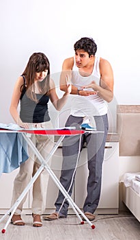 Young woman doing ironing for her husband