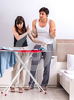 Young woman doing ironing for her husband