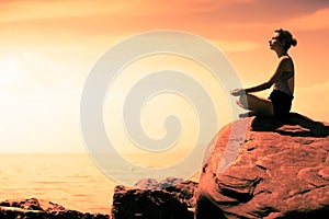 Young Woman doing Lotus Yoga Position in Front of the Ocean