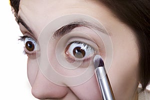 Young woman doing makeup