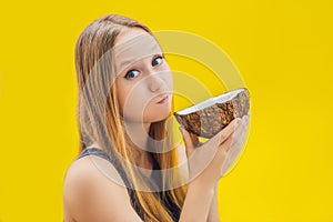 Young woman doing oil pulling over yellow background