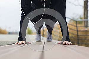 Young woman doing plank exercise working on abdominal muscles and triceps at outdoor