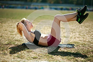 Young woman doing press fitness exercise for stomach muscles