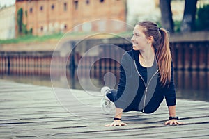 Young woman doing push up by the river