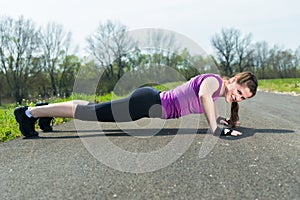 Young woman doing push ups .