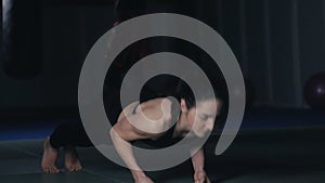 Young woman doing push-ups in fitness studio