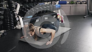 Young woman doing push ups in a gym
