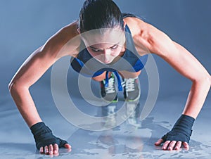 Young woman doing push ups on a mat.