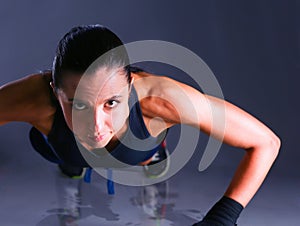 Young woman doing push ups on a mat