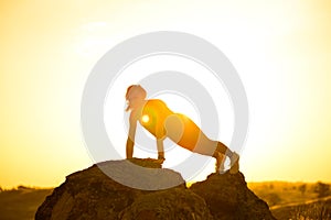 Young Woman Doing Push-ups in the Mountains. Workout Exercise at Sunset. Sport and Healthy Active Lifesyle Concept