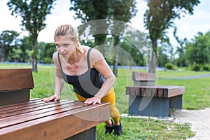 young woman doing push-ups outdoors