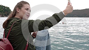 Young Woman Doing Selfie Sitting On Pier