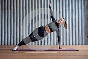 Young woman doing a side plank exercise.