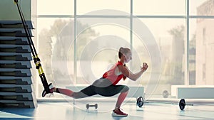 Young woman doing sit ups with the TRX.