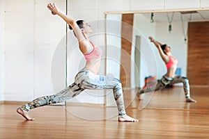 Young woman doing slimming exercise in the hall, yoga practice