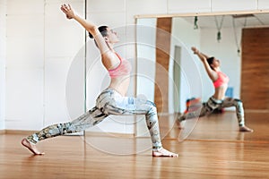 Young woman doing slimming exercise in the hall, yoga practice photo